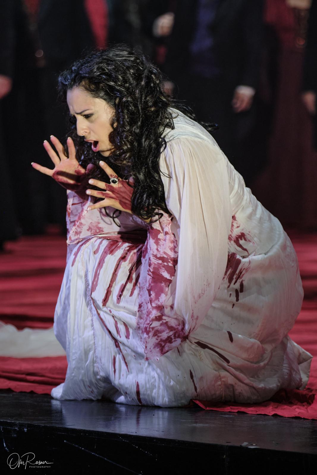 Hila Fahima in the title role of Lucia di Lammermoor, Tel Aviv 2024 — kneeling in a blood-stained nightgown, photo by Ofer Rosner
