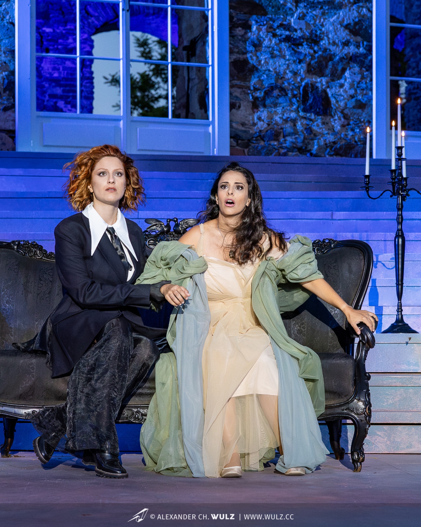 Hila Fahima as Violetta in La traviata, Oper Burg Gars 2025 — seated on the sofa beside Annina, photo by Alexander Wulz