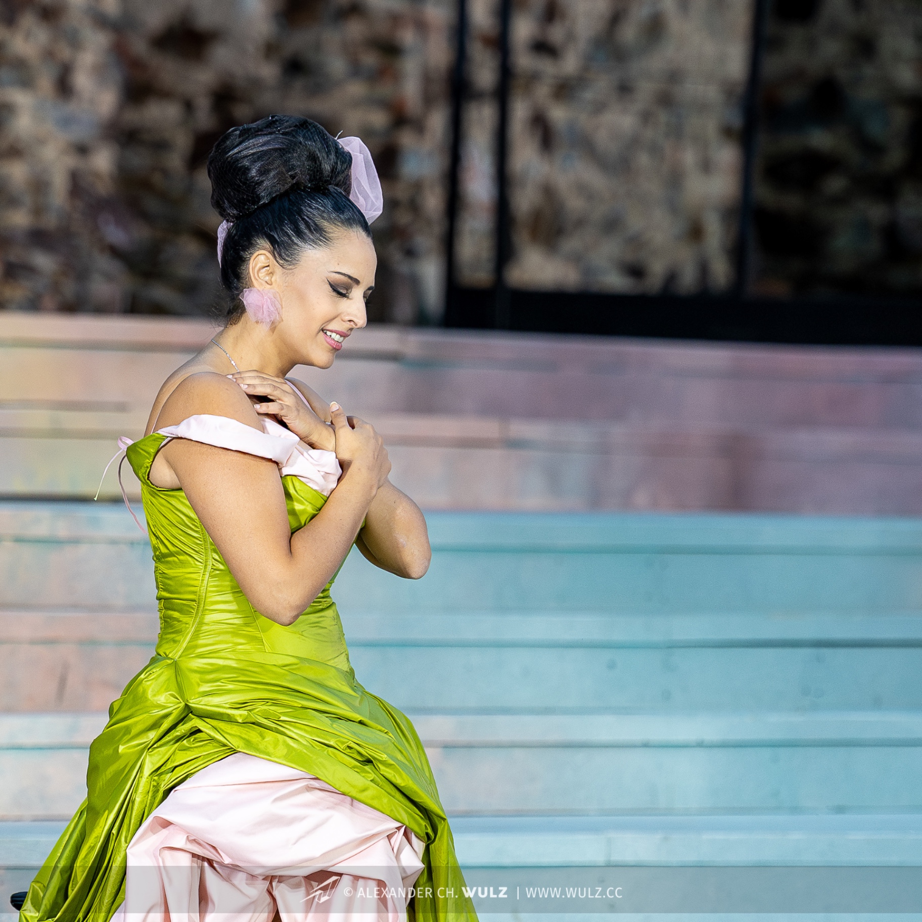 Hila Fahima as Violetta in La traviata, Oper Burg Gars 2025 — in profile, hands to her shoulder in a chartreuse gown, photo by Alexander Wulz