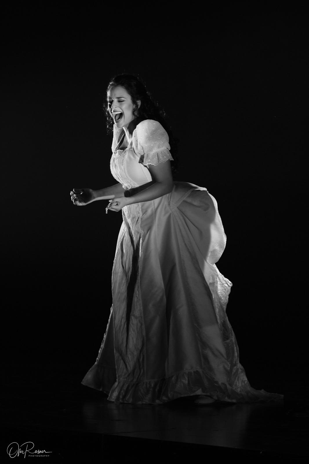 Hila Fahima in the title role of Lucia di Lammermoor, Tel Aviv 2024 — singing in the mad scene, black and white, photo by Ofer Rosner